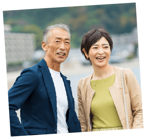 海辺を散策するシニア夫婦